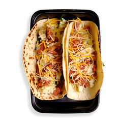 Two loaded up tacos fill this black togo container.  The tortillas are perfectly cooked and yellow and white shredded cheese sits atop fluffy eggs.  This is healthy prepared food for those looking to eat well while not depriving themselves of flavor!