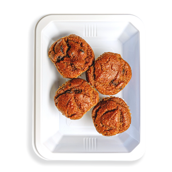 Inside a white takeout container there are four muffins that looks perfectly baked and all similar in size.  This is a healthy prepared breakfast meal for people on the go who want to watch what they are eating.