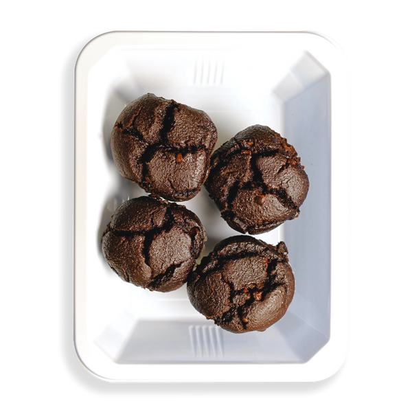 four really tasty looking muffins sit in this white togo container.  the contrast of the black, I'm assuming chocolate flavored muffins, in the white container looks extremely appealing.  If in fact this tasty looking food is very healthy than this is a game changer for those looking for healthy prepared meals.