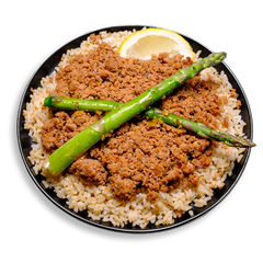 This vibrant health food meal showcases seasoned ground turkey, rich in protein and flavor from a blend of creole spices, onion powder, and lemon juice, laid over nutty brown rice. Two glistening roasted asparagus spears sit diagonally across the top, with a fresh lemon wedge adding brightness to this clean, colorful, and savory healthy prepared meal perfect for fitness-focused lifestyles.