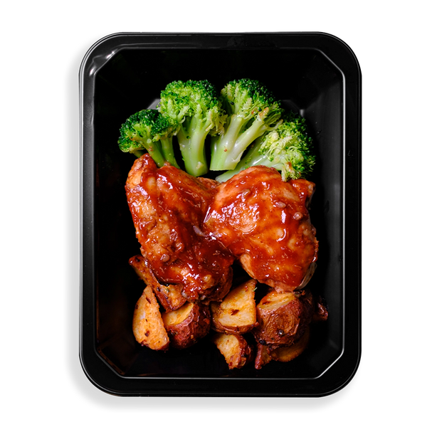 Filling this black prepared meal container are broccoli, chicken and red potatoes.  There are two large pieces of BBQ chicken and four very green piece of broccoli. The sauce on the chicken is rich and the flavor does not look to be lacking.