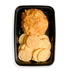 A large portion of shredded salmon with other tasty ingredients occupy half the black togo container with flavor while the remaining half contains very healthy looking crackers that are all in the shape of perfect circles. This appears to be the perfect healthy snack for busy people on the go.