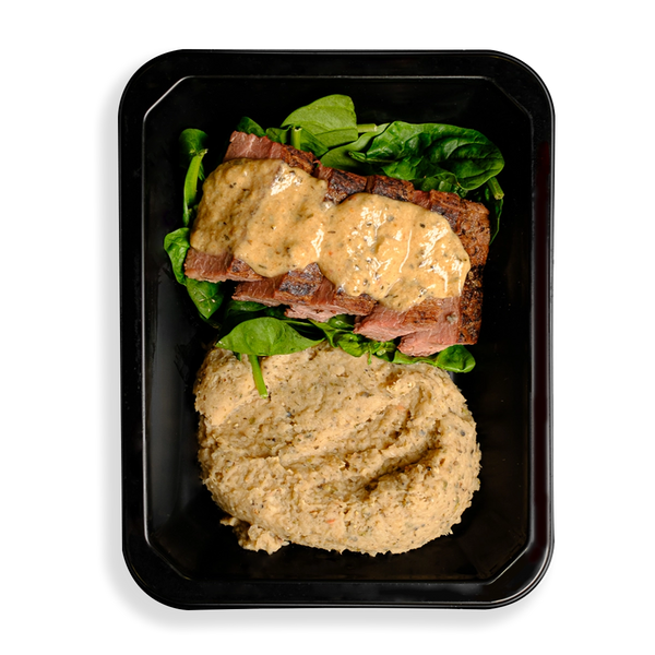 Sliced flank steak drizzled with creamy peppercorn sauce, resting on fresh spinach with a side of smooth herbed white bean purée, all neatly packed in a black to-go container.  The fact that this food looks so healthy and is packaged for delivery or instore pickup makes me think this is for busy people who want to eat well but are not always able to cook.